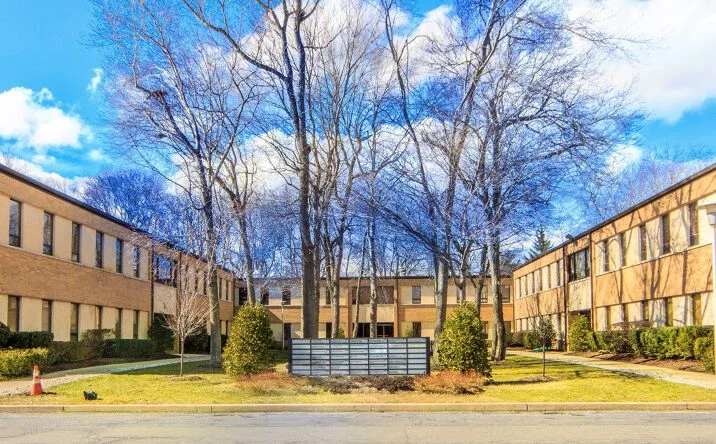 The two-story office building at 12 Roszel Road in Princeton, surrounded by mature trees